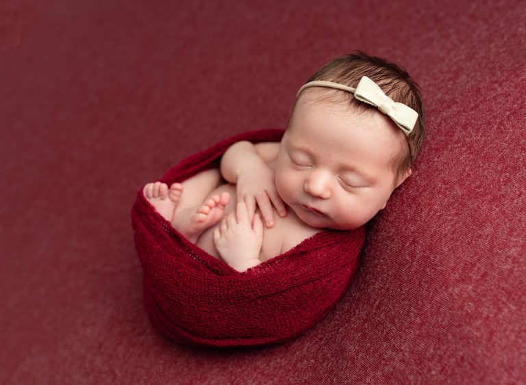 newborn baby girl on red