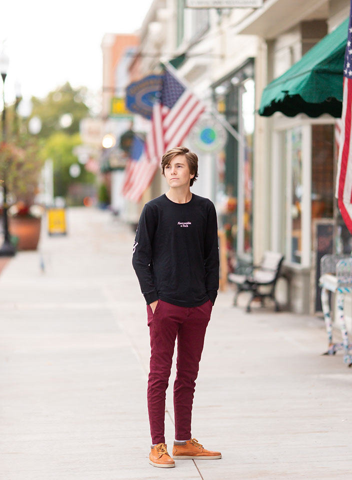 senior boy standing downtown