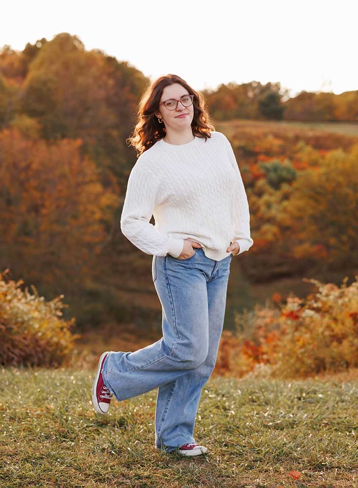 senior girl posing for pictures at top of hill