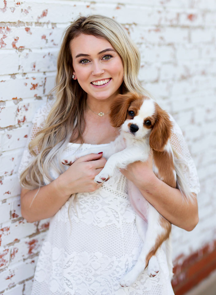 girl with dog posing for senior pictures