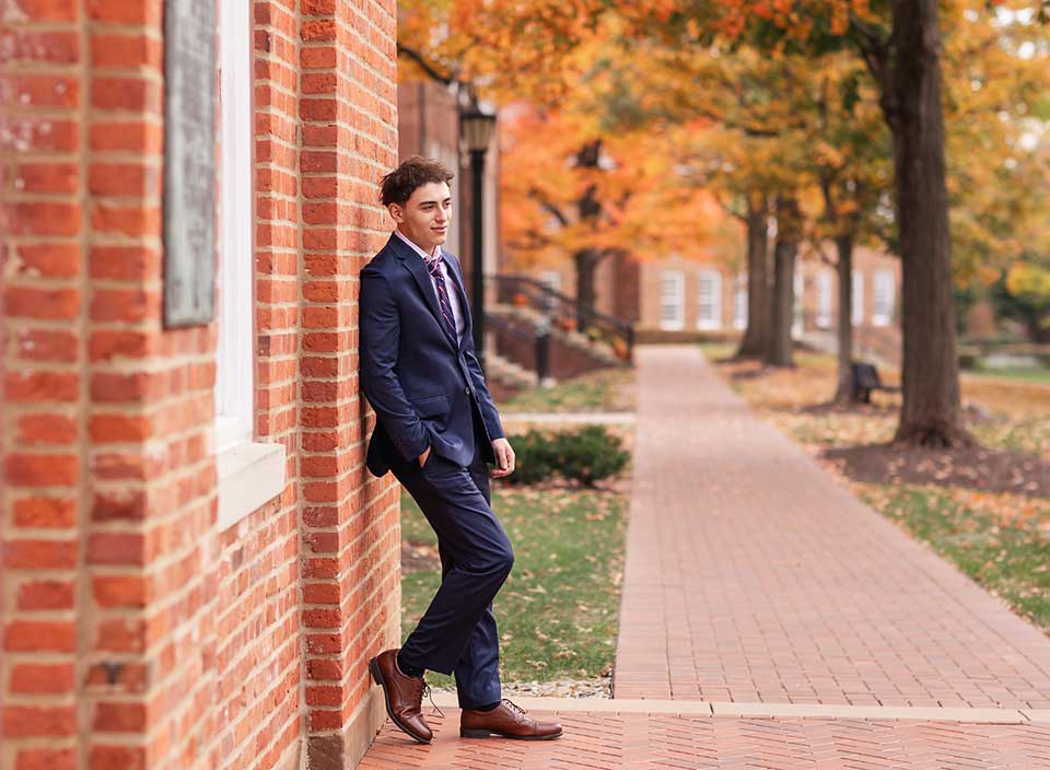 senior boy in suit posing for photos at WRA