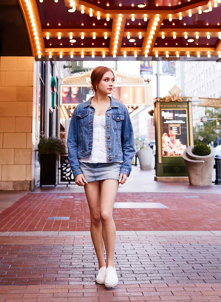 Teenage girl walking down city sidewalk