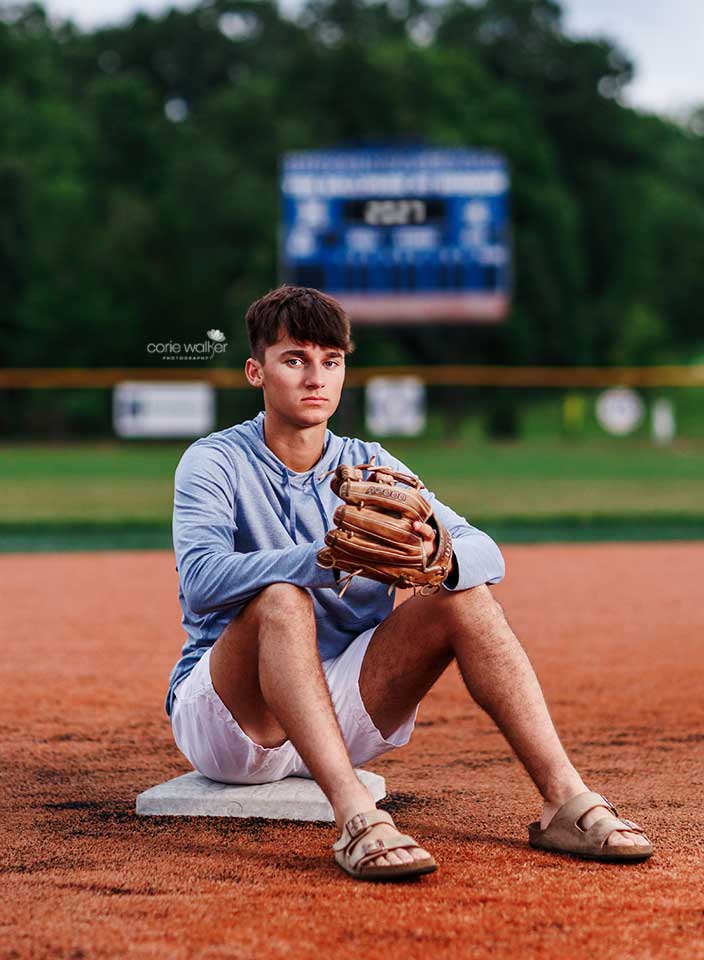 high school senior boy sitting on second base for photo