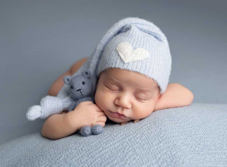 newborn boy wearing sleepy cap with heart