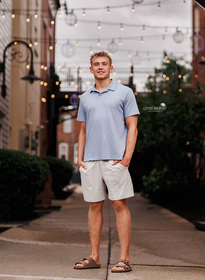 boy posing for senior photo in downtown Hudson