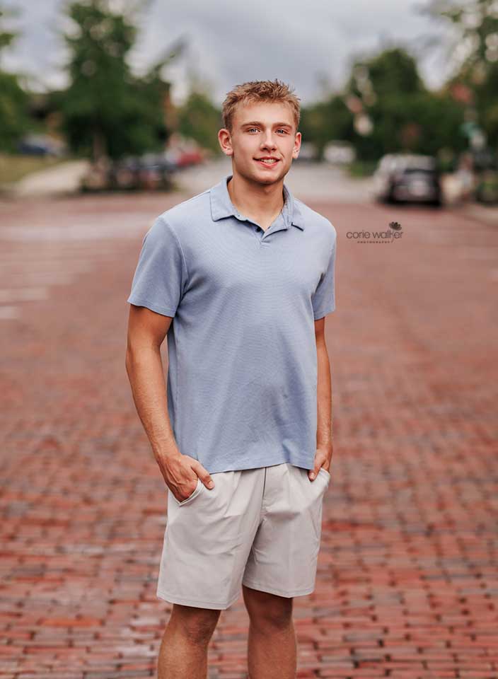 senior boy posing for photo on brick road